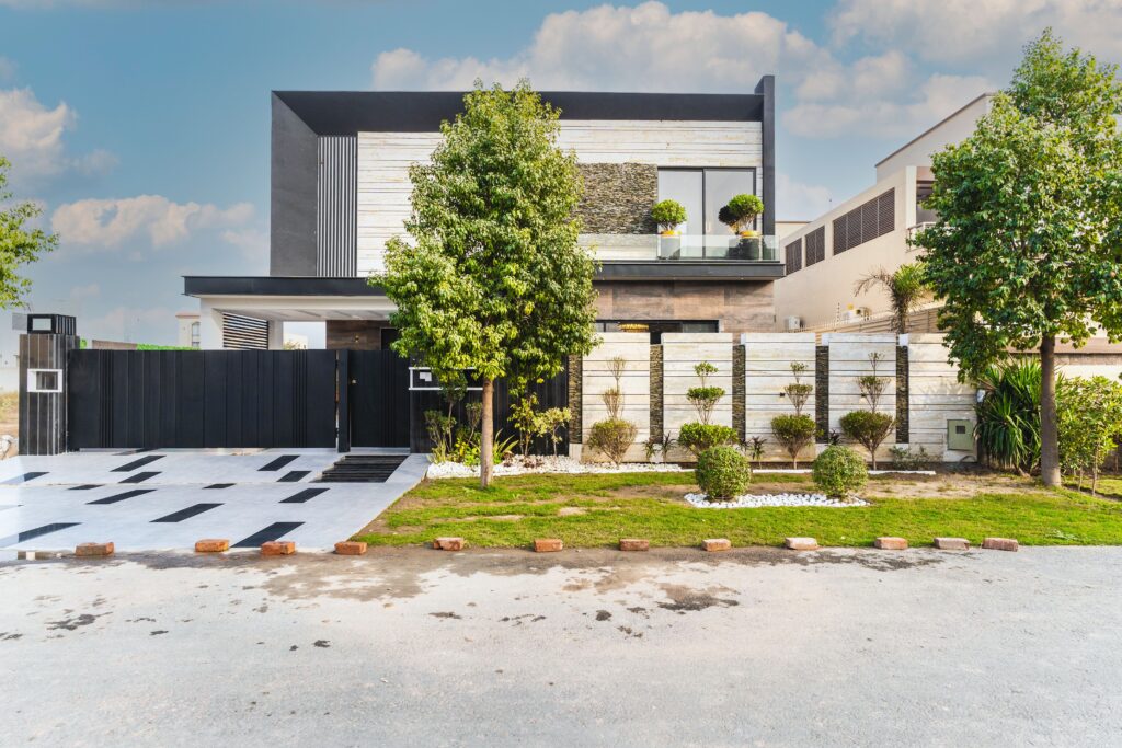 Contemporary house with sleek design in an urban street environment, featuring modern architecture and greenery.