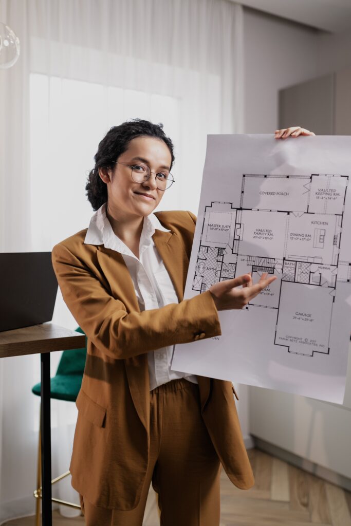 Female architect presenting a detailed floor plan indoors, showcasing design expertise.